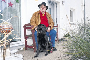 Jürgen Dreher sitzt auf einer Bank, vor ihm sein Hund Bodo.