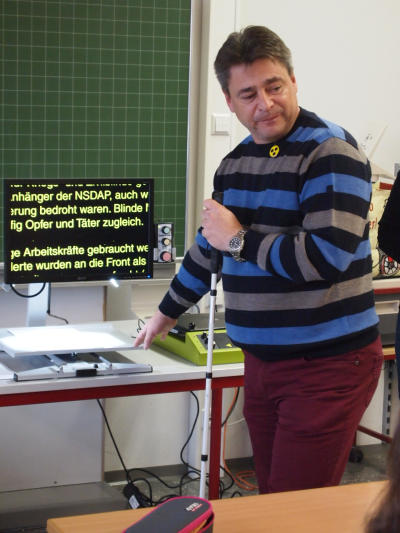 Harald Eigler zeigt ein Bildschirmlesegerät